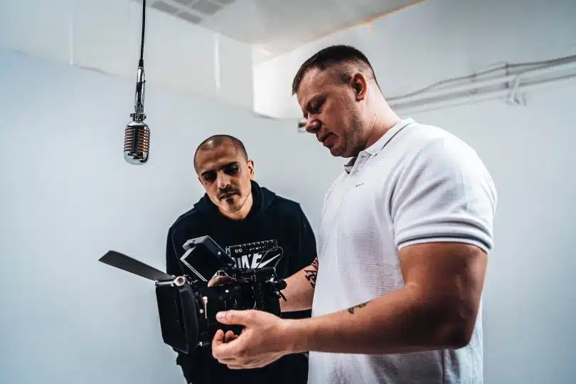 man in white crew neck t-shirt holding black camera